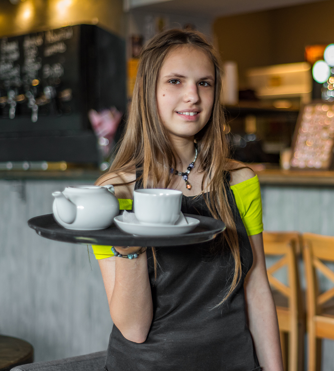 A young woman working in a coffee shop thanks to support from Opportunity and Change